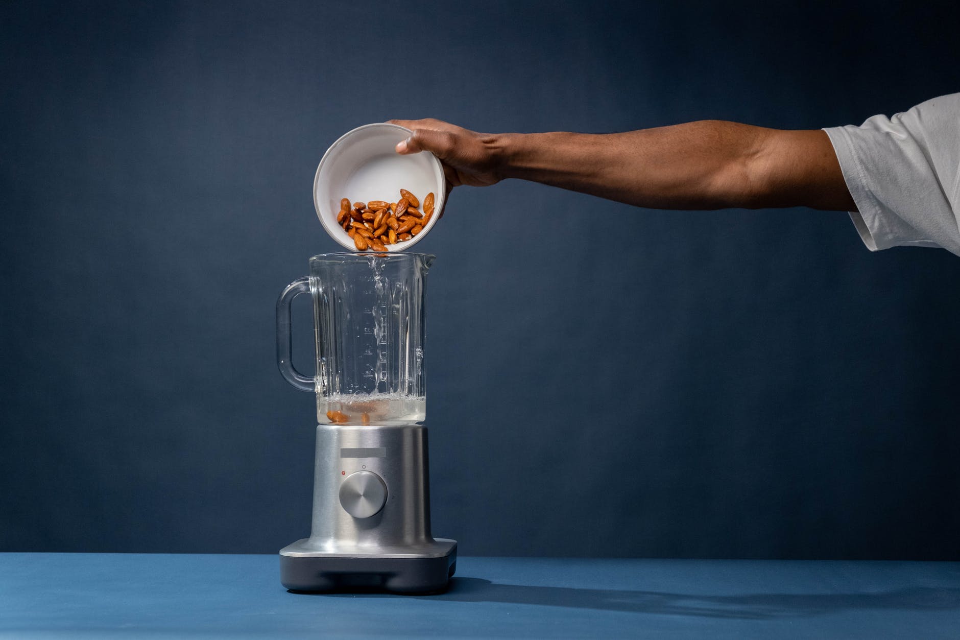 pouring of pecan nuts on a blender